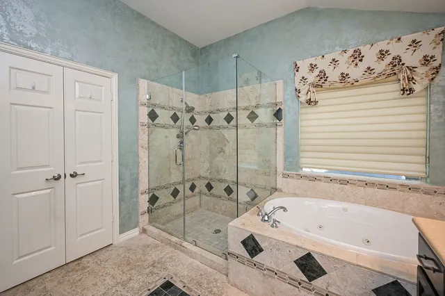 a spacious bathroom with a double vanity sink mirror and shower