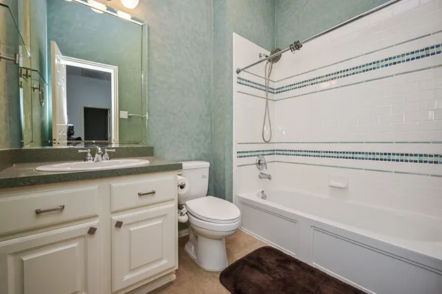 an empty room with a chandelier fan and windows