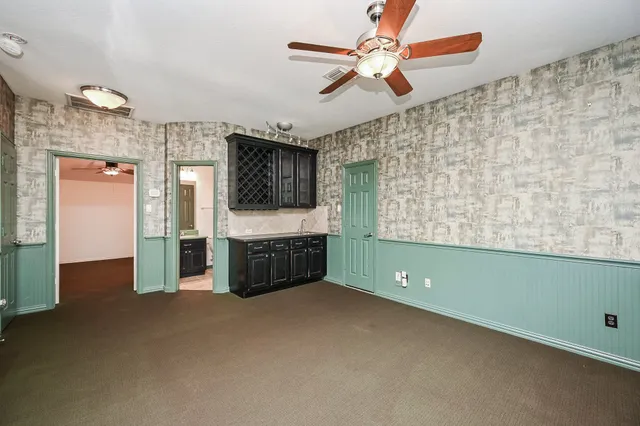 a view of an empty room with window and cabinet