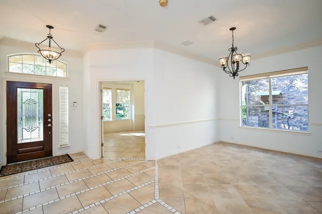 a dining room with furniture a chandelier and window