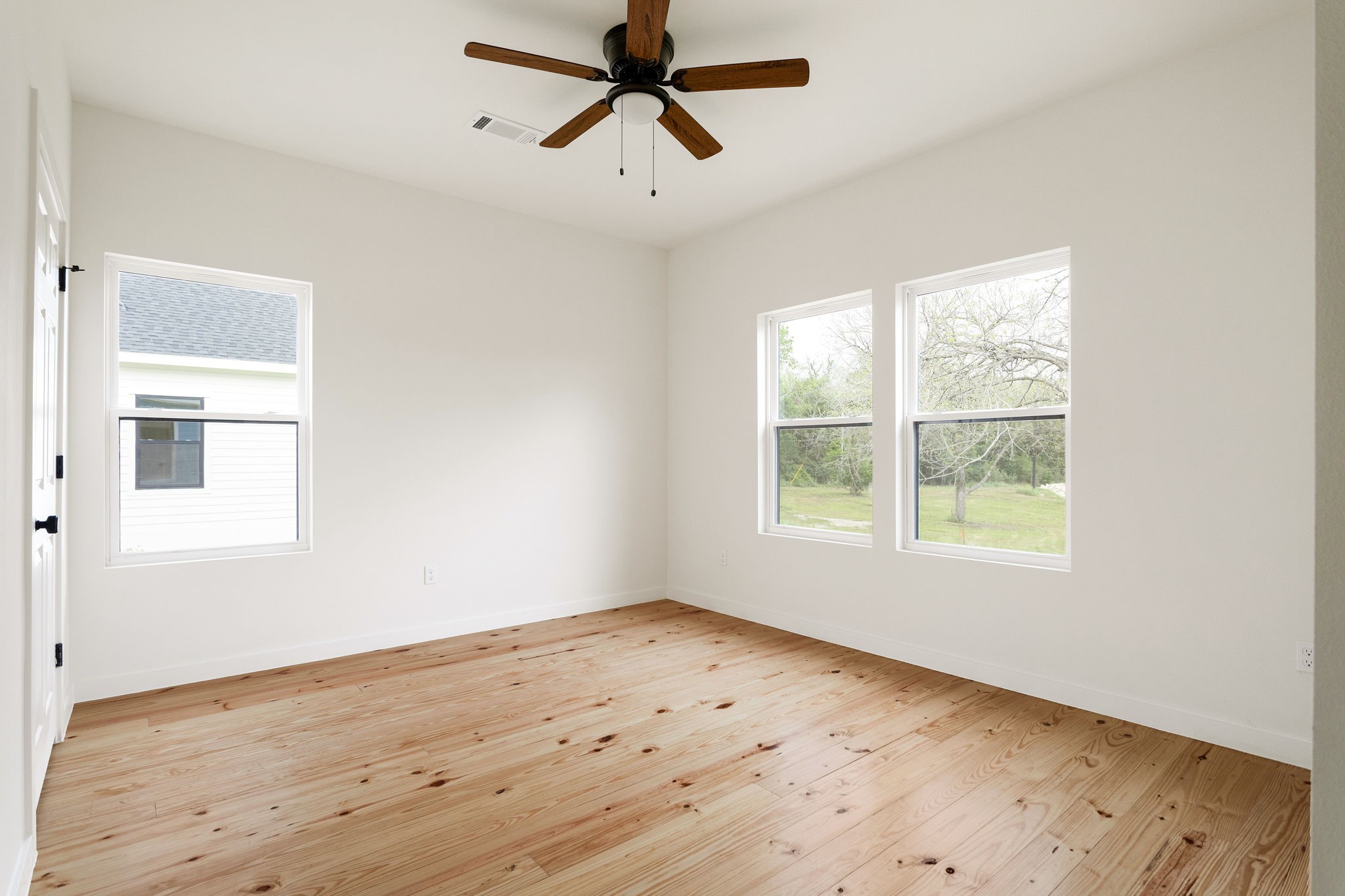 226 North Dixie Street Brenham, TX 77833 - Photo 11 of 22 a view of empty room with wooden floor and window