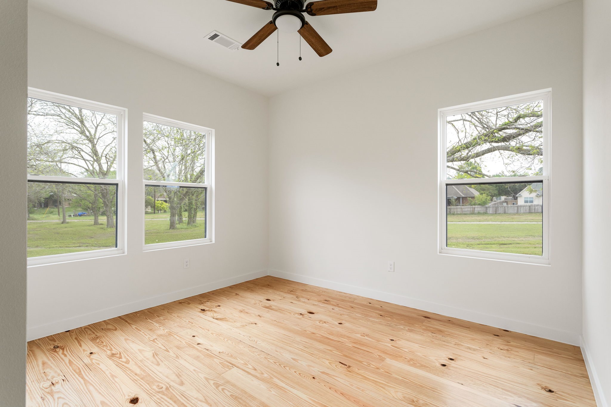 226 North Dixie Street Brenham, TX 77833 - Photo 17 of 22 a view of an empty room with wooden floor and a window