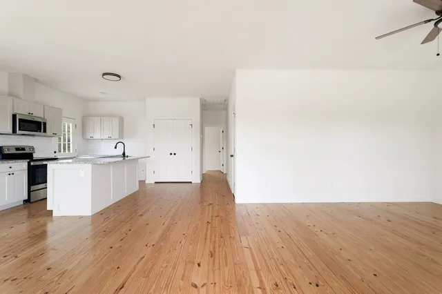 a view of kitchen with wooden floor and electronic appliances