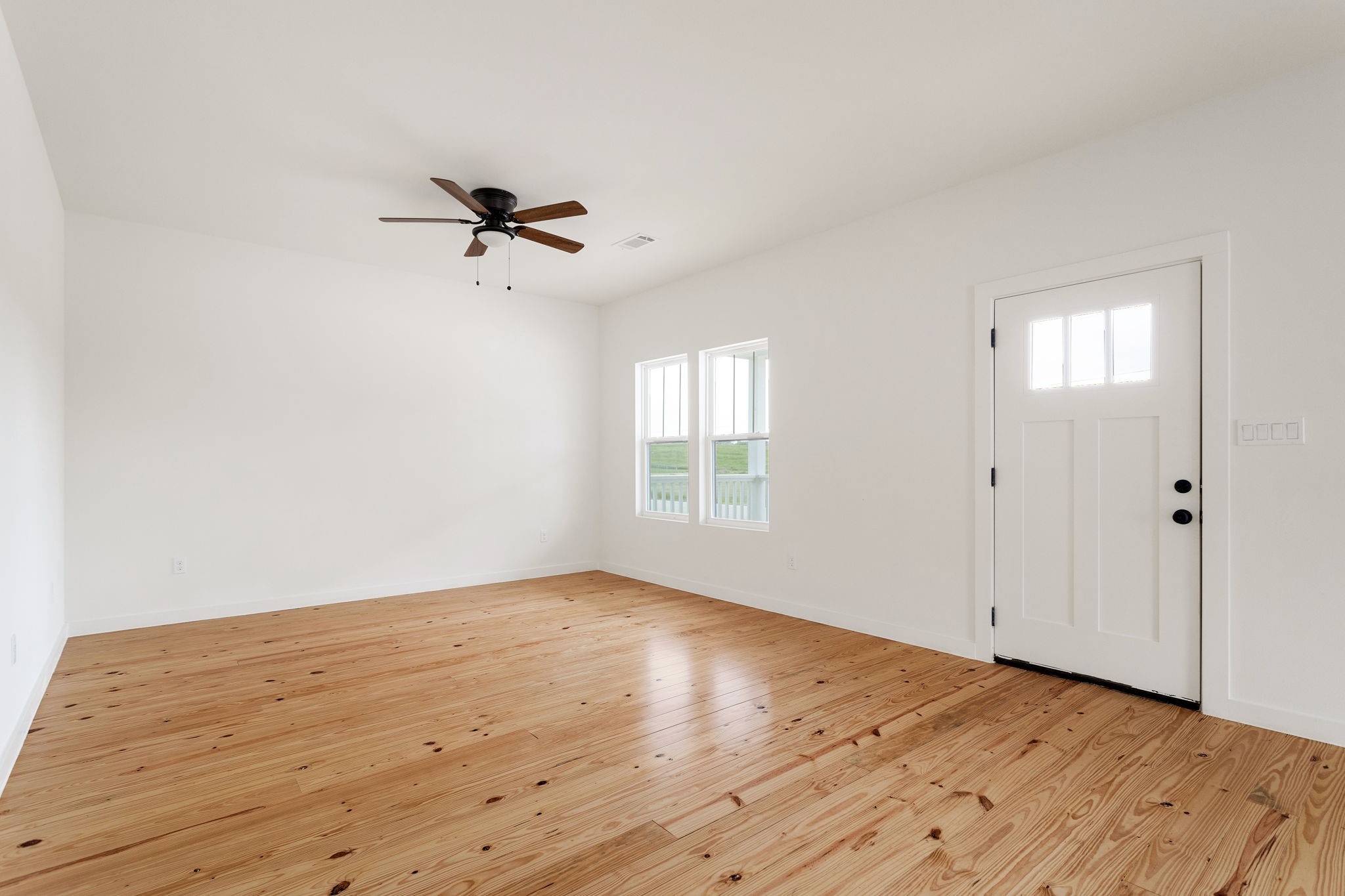 226 North Dixie Street Brenham, TX 77833 - Photo 3 of 22 an empty room with wooden floor ceiling fan and windows