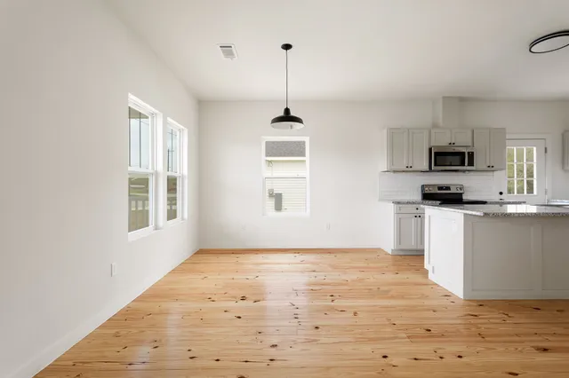 a kitchen with kitchen island white cabinets and window