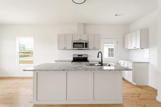 a kitchen with granite countertop a sink and a stove