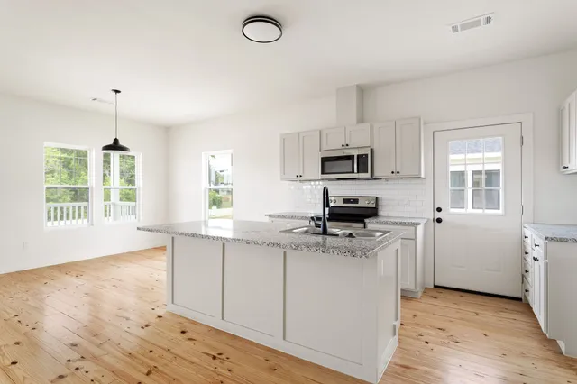 a kitchen with a sink stove and microwave