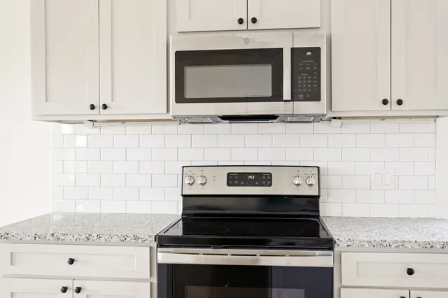 a stove top oven sitting inside of a kitchen