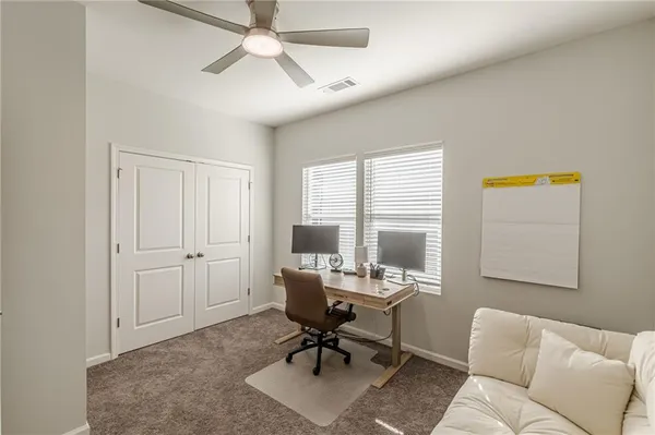 a living room with furniture and a ceiling fan