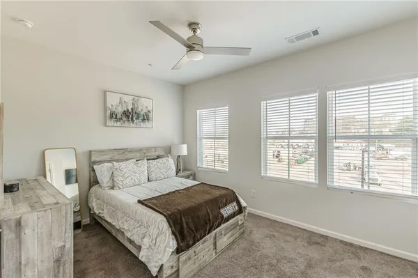 a bedroom with a bed and a flat tv screen on the dresser