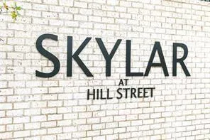 an aerial view of a city with lots of residential buildings ocean and mountain view in back