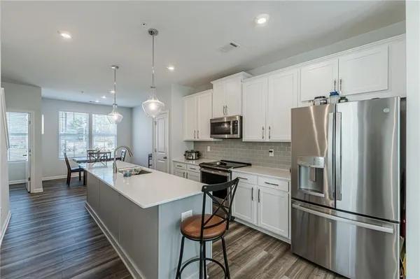a kitchen with stainless steel appliances a refrigerator stove microwave and cabinets