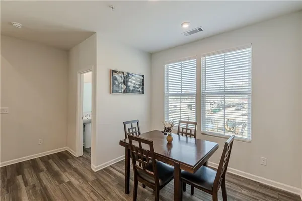 a view of a a dining room with furniture window and wooden floor