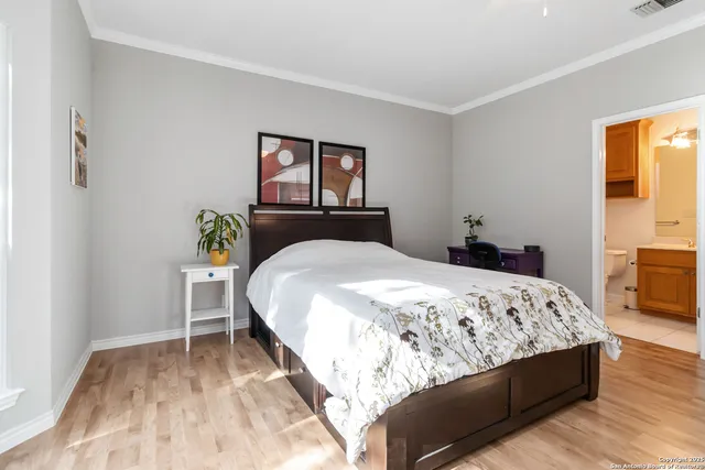 a bedroom with a bed and painting on the wall