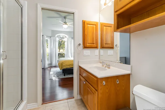a en suite bathroom with a granite countertop sink and a mirror