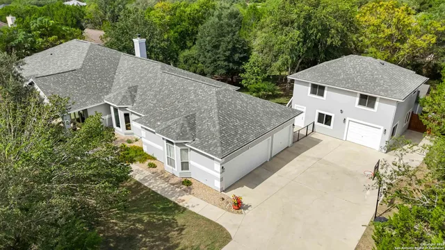 a aerial view of a house with a yard and large trees