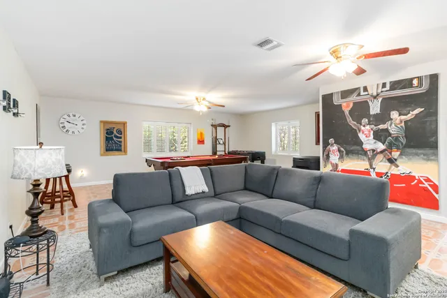 a living room with furniture and a ceiling fan