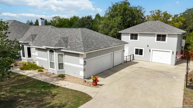 a white house with a large yard and large tree
