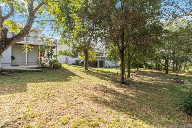 a view of a house with large trees and a big yard
