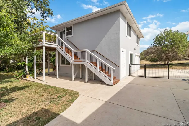 a view of a house with basket ball court and wooden fence