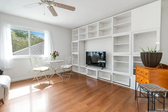 a living room with furniture a flat screen tv and floor to ceiling window