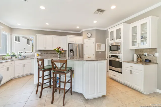 a kitchen with stainless steel appliances kitchen island granite countertop a table and chairs in it
