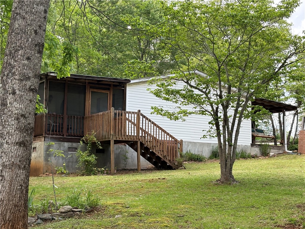 155 Hickory Ridge Mountain Rest, SC 29664 - Photo 2 of 21 Mature trees frame a charming home featuring a wooden porch and private, grassy yard.