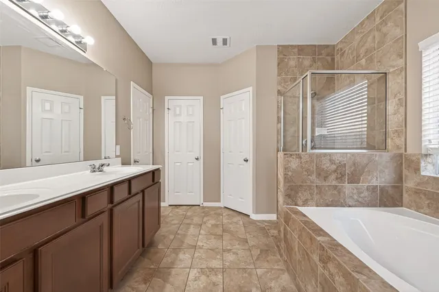 a bathroom with a tub sink and mirror