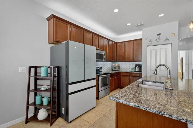 a kitchen with stainless steel appliances granite countertop a refrigerator sink and cabinets