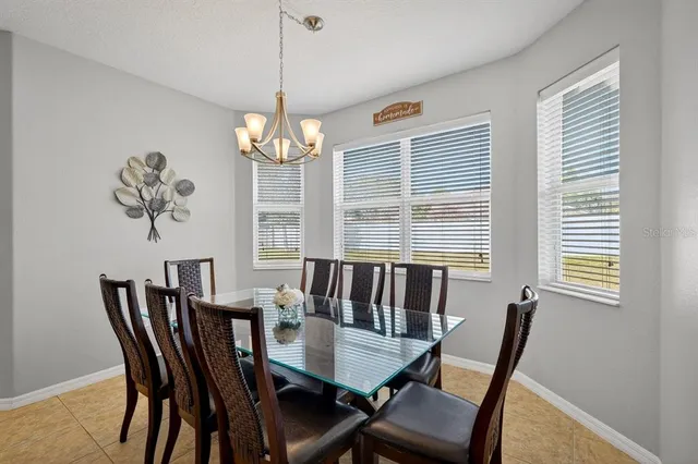 a view of a dining room with furniture a chandelier and wooden floor