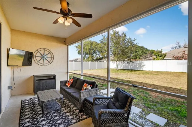 a living room with furniture floor to ceiling window and a table