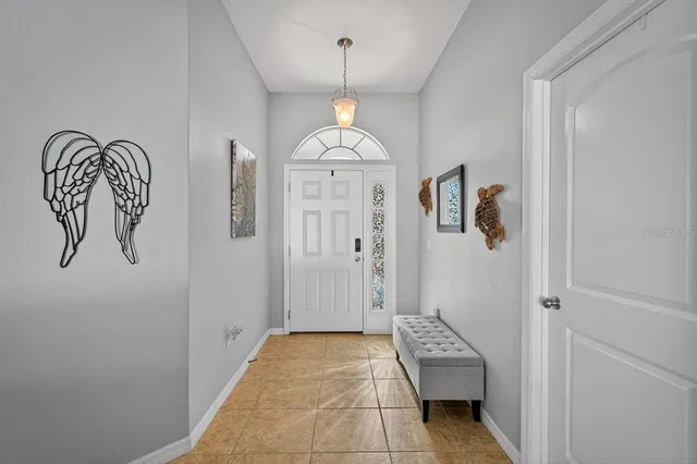 a hallway with painting and a chandelier