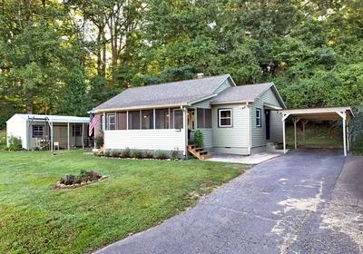 a front view of a house with a garden and trees