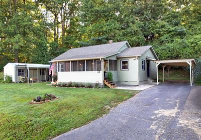 a front view of a house with a garden and trees