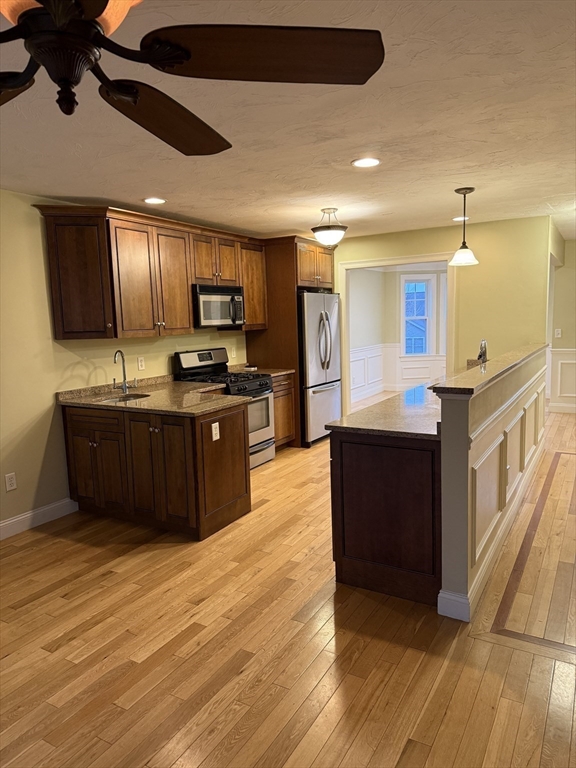 30 Johnson Street, Unit 1 Worcester, MA 01604 - Photo 3 of 24 a large kitchen with stainless steel appliances kitchen island granite countertop a large counter top and a stove