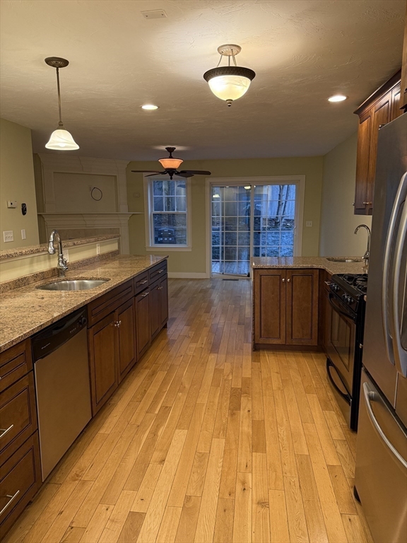 30 Johnson Street, Unit 1 Worcester, MA 01604 - Photo 5 of 24 a large kitchen with kitchen island a sink wooden floor and stainless steel appliances