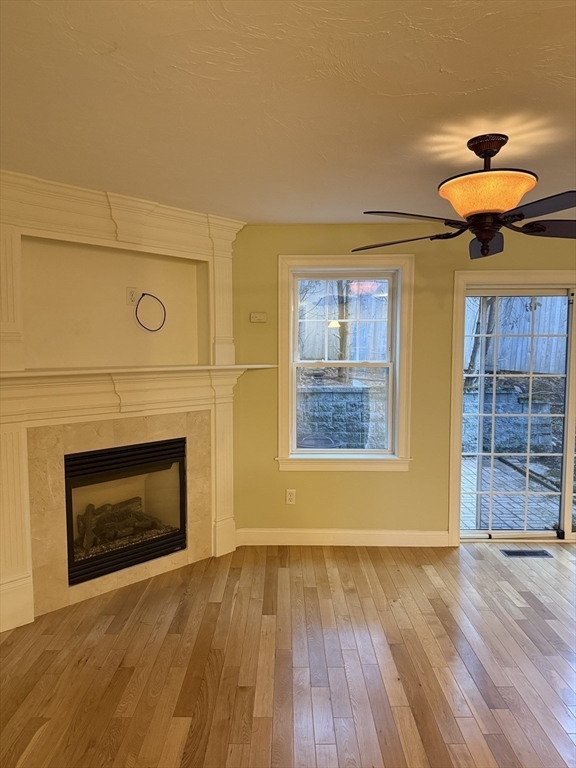 30 Johnson Street, Unit 1 Worcester, MA 01604 - Photo 8 of 24 a view of an empty room with wooden floor and a fireplace