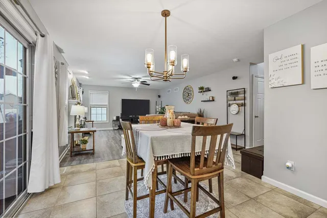 a view of a dining room with furniture a chandelier and wooden floor