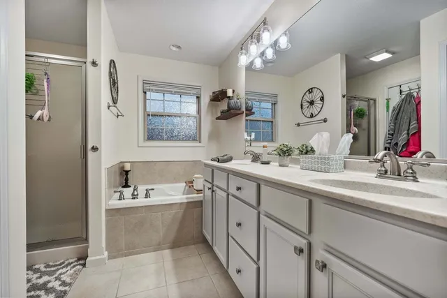 a bathroom with a tub sink and mirror