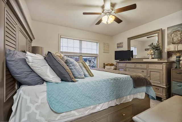 a bedroom with a bed and ceiling fan