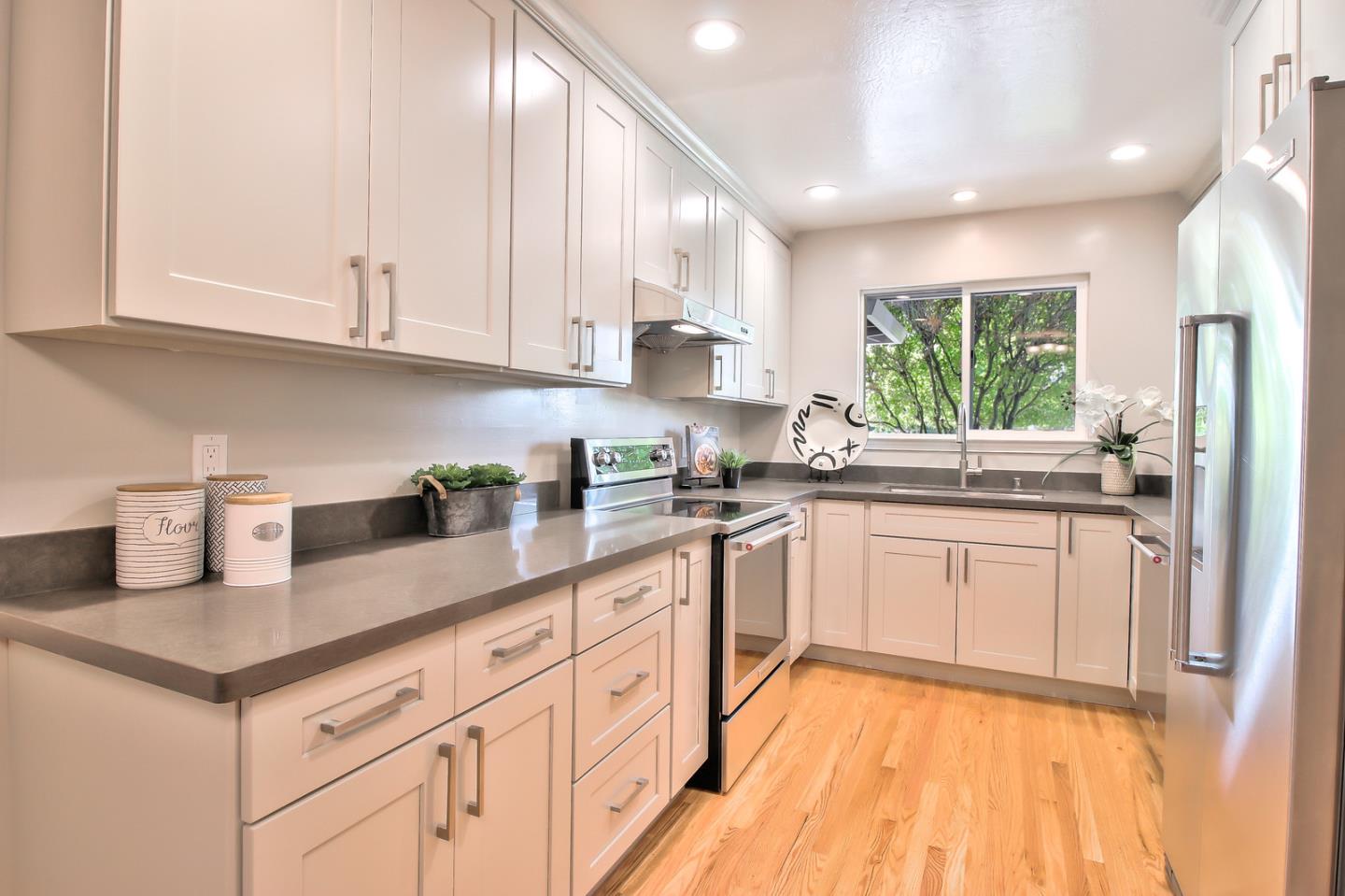 2128 Vía D'Este Campbell, CA 95008 - Photo 15 of 33 a kitchen with granite countertop white cabinets white appliances a sink and a window