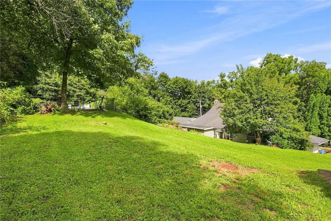 3408 Oak Hill Road Emmaus, PA 18049 - Photo 55 of 93 Mature trees frame a rolling green lawn sloping toward the home under a blue sky.
