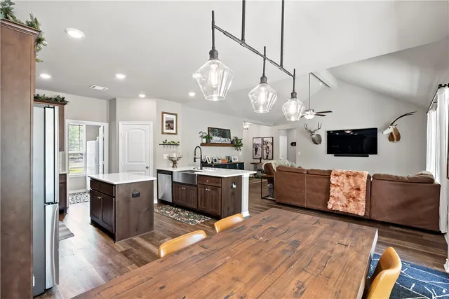 a kitchen with a stove a sink a dining table and chairs