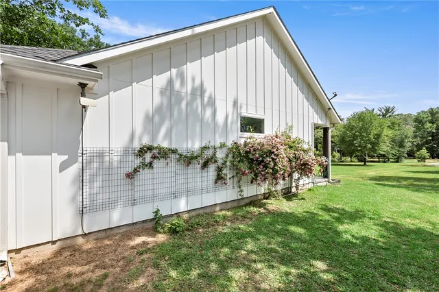 a view of a house with backyard and trees