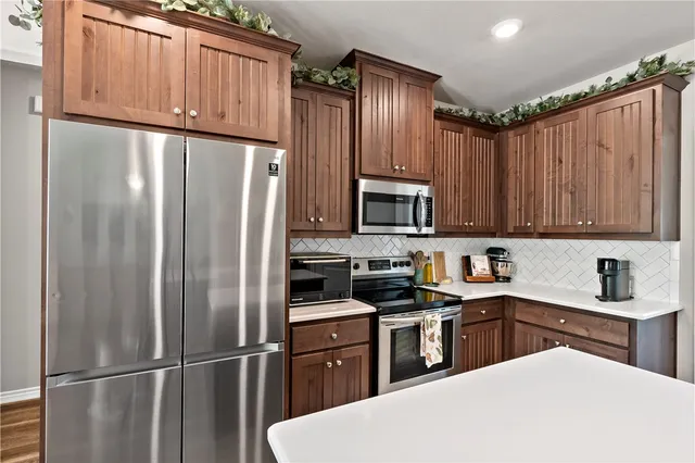 a kitchen with kitchen island granite countertop a refrigerator stove and sink