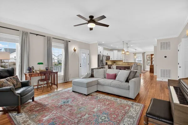 a living room with furniture and a wooden floor