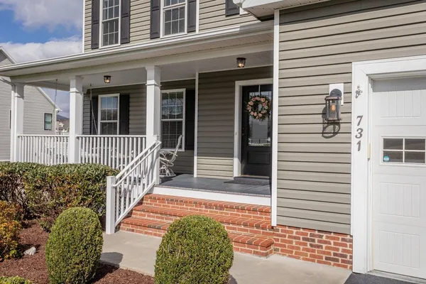 a kitchen with stainless steel appliances kitchen island granite countertop a refrigerator a stove a microwave oven a sink with island and chairs with wooden floor