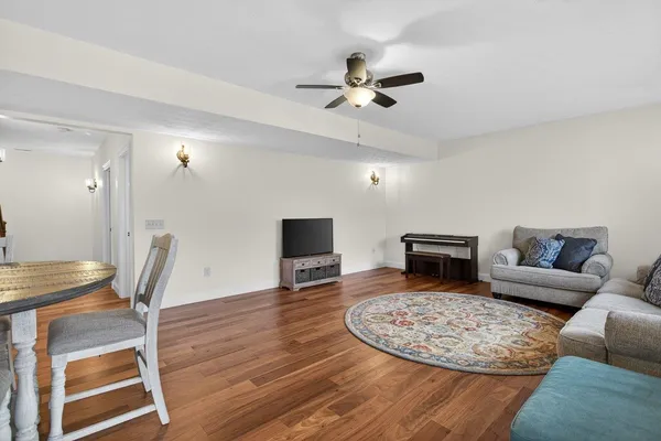 a view of a livingroom with wooden floor and a bathroom
