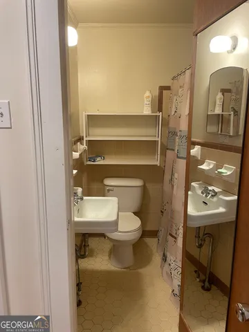a view of an empty room with wooden floor and closet