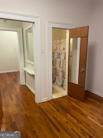 a view of a hallway with wooden floor and a living room